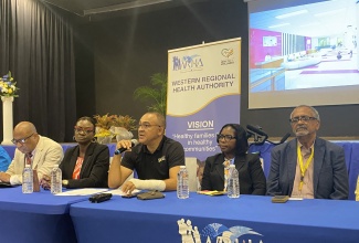 Minister of Health and Wellness, Dr. the Hon. Christopher Tufton (centre), gives an update on the construction of the Western Children and Adolescent Hospital (WCAH), during a press briefing at the Royalton Negril Hotel on Tuesday (June 25). He is joined at the head table by (from left) Regional Director, Western Regional Health Authority (WRHA), St. Andrade Sinclair; Senior Medical Officer, WCAH, Dr. Carleene Grant Davis; Director of Nursing, WCAH, Allison Chambers; and Clinical Coordinator at the Western Regional Health Authority (WRHA), Dr. Delroy Fray.

