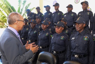 Minister of National Security, Hon. Dr. Horace Chang (left), converses with new police recruits at the National Police College of Jamaica at Twickenham Park, St. Catherine, on Tuesday (June 25).