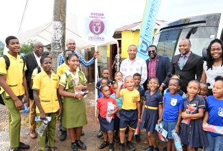 tate Minister in the Ministry of Finance and the Public Service, Hon. Zavia Mayne (background, third left), is joined by representatives from the Universal Service Fund (USF), students of Murray Mountain Primary and Infant School and Grants Mountain Primary School and other stakeholders, during the launch of Community Wi-Fi service in the Glasgow Lodge District in Murray Mountain, St. Ann, on Friday (June 21)