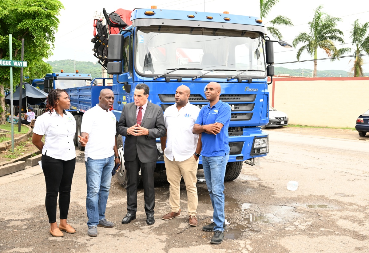 Executive Director, National Solid Waste Management Authority (NSWMA), Audley Gordon (second left), speaks with Minister of State in the Office of the Prime Minister (West), Hon. Homer Davis (centre), during the relaunch of Operation SWEEP at WPM Limited