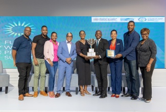 Sharing in team NHT’s excitement is The Honourable Pearnel Charles Jr. MP, Minister of Labour and Social Security (fourth right) and Dr. the Honourable Norman Dunn, Minister of State in the Ministry of Labour and Social Security (fourth left). 

Team NHT (from left): Ainsley McDonald, Acting Manager, Loan Accounting; Roshane 
Thompson, Acting Loan Portfolio Officer; Shaniek Robinson, Acting ISO 9001 Project 
Manager; Dr Suzanne Wynter, General Manager Loan Manager; Dr Lanie Oakley-Williams, Senior General Manager, Customer Relations Management; Damion Reid, 
Acting Manager, Loan Management and Shirley Pryce, Senior Social Development 
Officer.