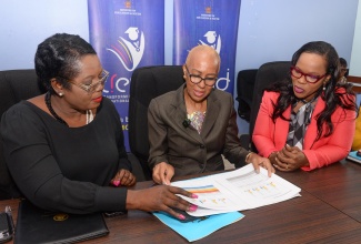 Minister of Education and Youth, Hon. Fayval Williams (centre), peruses the 2024 Primary Exit Profile (PEP) results with Acting Chief Education Officer in the Ministry, Terry Ann Thomas Gayle (left), and Permanent Secretary, Dr. Kasan Troupe, during a press conference at the Ministry in Kingston on Friday (June 21).