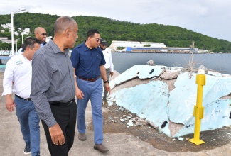 Prime Minister the Most Hon. Andrew Holness (right), examines the damage done at the Ocho Rios Pier in St. Ann, during a tour of the facility on Friday (June 21) with Chief Executive Officer of the Port Authority of Jamaica (PAJ), Professor Gordon Shirley (left). Others present from (background, left) are Minister without Portfolio in the Ministry of Economic Growth and Job Creation, Senator the Hon. Matthew Samuda; Senior Strategist and Advisor in the Ministry of Tourism, Delano Seiveright and Mayor of St Ann’s Bay, Councillor Michael Belnavis.