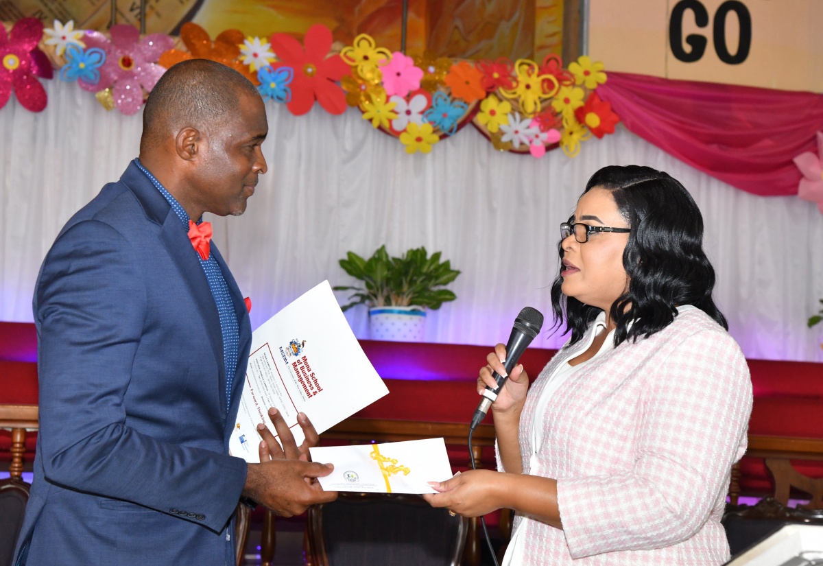 Chief Executive Officer of the Child Protection and Family Services Agency, Laurette Adams Thomas (right) presents a cheque for $50,000 to the Pastor, Portmore Seventh- Day Adventist Church, Francis West, which will go towards the children’s ministry at the church. The presentation was made during the CPFSA