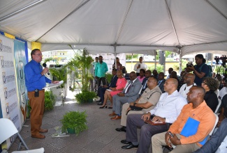 Minister of Science, Energy, Telecommunications and Transport, Hon. Daryl Vaz, delivers the keynote address at the launch of a public Wi-Fi hotspot at University Square in Papine, St. Andrew, on Wednesday (June 26) by the Universal Service Fund (USF). Listening are Minister of Education and Youth, Hon. Fayval Williams (second left, seated) and Mayor of Kingston, Councillor Andrew Swaby (left, seated).

