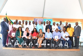 Minister of Science, Energy, Telecommunications and Transport, Hon. Daryl Vaz (standing, centre), shares a photo opportunity with the first batch of certified driving instructors and members of the Island Traffic Authority (ITA), at the certification ceremony held on Wednesday (June 19), at the Ministry’s Maxfield Avenue location in Kingston.

