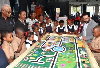 State Minister in the Ministry of Education and Youth, Hon. Marsha Smith (fifth left), looks on while Robotics Instructor, Zebra Robotics in Canada, Tahmoor Naeem (second right), conducts a robotics lesson with students from Bryce Primary School in Manchester. Occasion was the recent launch of a robotics camp, being staged by local firm Zed Technology in collaboration with Zebra Robotics, at the Karl Hendrickson Auditorium, Jamaica College. Others looking on are Managing Director of Zed Technology, Carlton Grant (second left) and Principal of Bryce Primary, Mavilla White (seventh left).

