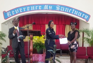 Constable Shaniek Johnson, who is attached to the Guanaboa Vale Station in St. Catherine, presents a cheque valued $150,000 on behalf of the Jamaica Ex-Police Association of South Florida (JEPA) Inc. to 15-year-old Rayona Edwards, at the Kitson Town Seventh-day Adventist (SDA) Church in St. Catherine, on June 15. At left is Principal of the Kitson Town Institute, Michael McDonald.

