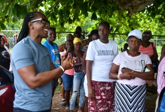 Minister of State in the Ministry of Foreign Affairs and Foreign Trade, Hon. Alando Terrelonge (left), speaks with residents prior to handing out care packages containing food items at Goodwill Primary and Infant School in St. James on Thursday (June 20). Approximately 100 packages were distributed to needy persons in partnership with Food For the Poor as part of Diaspora Day of Service. Approximately 14 projects were undertaken across the island throughout the Day, which concluded the 10th Biennial Jamaica Diaspora Conference that commenced on Sunday (June 16) at the Montego Bay Convention Centre in St. James.

