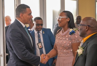 Prime Minister, the Most Hon. Andrew Holness (left), is greeted by President of the Jamaica Civil Service Association (JCSA), Techa Clarke-Griffiths, on his arrival at JACISERA Park, in St. Andrew on May 30, for the Jamaica Civil Service Association (JCSA) 105th annual general meeting. At right is 1st Vice President, JCSA, Clarence Frater.