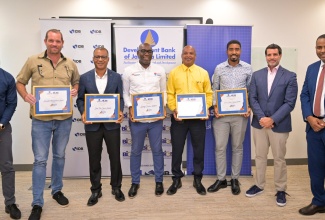 General Manager, Project Management Office, Development Bank of Jamaica (DBJ), Hugh Grant (right); Chief of Operations, Inter-American Development Bank (IDB), Lorenzo Escondeur (second right); and Programme Manager, Boosting Innovation, Growth and Entrepreneurship Ecosystems (BIGEE),  Christopher Brown (left),  share a photo opportunity with representatives from five beneficiary companies under cohort five of the BIGEE Jamaica Business Fund (JBF). Occasion was the official signing ceremony for grant support to the five entities at the IDB head office in Kingston on June 12. From second left are General Manager, Associated Manufacturers Limited, Jason Garbutt; Chief Executive Officer, Spur Tree Spices Limited, Albert Bailey; Owner, Synergy Business Solution, Derron Grant; Director, Jerkorama Company Limited, Clive Myrie; and Director, E&A Jones Company Limited, Matthew Jones.