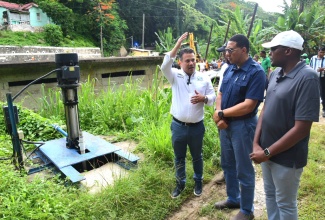 Prime Minister, the Most Hon. Andrew Holness (centre), is updated on developments regarding the water pump infrastructure serving the community of Pimento Walk in St. Ann by Minister without in the Portfolio Ministry of Economic Growth and Job Creation with Responsibility for Water, Environment, Climate Change, and the Blue and Green Economies, Senator the Hon. Matthew Samuda (left). The occasion was a tour of work being done in the community, on June 21. Accompanying them are Minister without Portfolio in the Ministry of Economic Growth and Job Creation with responsibility for Works, Hon. Robert Nesta Morgan (right), and Mayor of St. Ann’s Bay, Councillor Michael Belnavis (second left, partially hidden). 