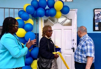 Principal of Ocho Rios Primary School, Suzette Wilson (left), applauds as Custos of St. Ann, Norma Walters (centre), cuts the ribbon for the newly installed computer lab at a ceremony at the school on June 4. At right is Businessman, Kumar Sujanani, who retrofitted the lab.