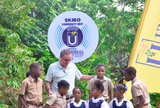 Minister of Science, Energy, Telecommunications and Transport, Hon. Daryl Vaz, interacts with students of Skibo Primary School during the launch of community Wi-Fi service in Skibo, Portland, earlier this year. The facility was installed by the Universal Service Fund (USF).

