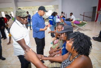 Labour and Social Security Minister and Member of Parliament for Clarendon South Eastern, Hon. Pearnel Charles Jr. (left), and  Prime Minister, the Most Hon. Andrew Holness (right), meet with residents of Rocky Point in Clarendon, at the Rocky Point Community Centre, on Saturday, July 6.

