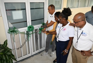 Minister of Health and Wellness, Dr. the Hon. Christopher Tufton (left), cuts the ribbon to officially open a newly renovated operating theatre at the Falmouth Public General Hospital in Trelawny on Friday (July 26). He is joined by (from 2nd left), Parish Manager for Trelawny Health Services, Keriesa Bell Cummings; Chief Executive Officer (CEO) of the Falmouth Public General Hospital, Princess Wedderburn; and Regional Director, Western Regional Health Authority (WRHA), Andrade Sinclair. 