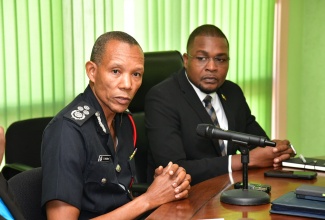 Commissioner of the Jamaica Fire Brigade (JFB), Stewart L. Beckford (left), addresses a meeting of the National Disaster Risk Management Council at the Ministry of Local Government and Community Development in Kingston on Monday (July 1). Looking on is Minister without Portfolio in the Ministry of Economic, Growth and Job Creation with the responsibility for Works, Hon. Robert Nesta Morgan.