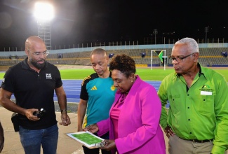 Minister of Culture, Gender, Entertainment and Sport, Hon. Olivia Grange (second right), discusses the new lighting system at the National Stadium with (from left) Chief Executive Officer (CEO) of Phase 3 Productions, Delano Forbes; General Secretary of the Jamaica Football Federation (JFF), Dennis Chung; and General Manager of Independence Park Limited, Major Desmon Brown. Occasion was the testing of new lights at the stadium in Kingston on Wednesday (July 24).