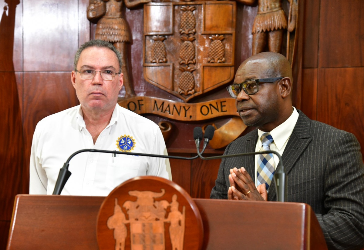 Minister of Science, Energy, Telecommunications and Transport, Hon. Daryl Vaz (left), listens as Director General of the Office of Utilities Regulation (OUR), Ansord Hewitt, addresses Wednesday