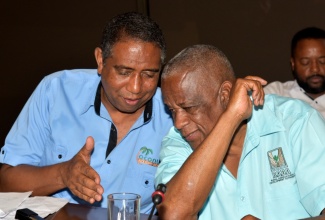 Minister of State in the Ministry of Agriculture, Fisheries and Mining, Hon. Franklin Witter (right), consults with Coconut Industry Board (CIB) Chairman, Christopher Gentles, during the recent Coconut Growers Annual General Meeting at the Jamaica Conference Centre in downtown Kingston.


