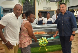 Prime Minister, the Most Hon. Andrew Holness (right), assists Averil Smith to cut the ribbon to officially open the Wholesome Café at the Digicel Food Court, downtown Kingston, on Sunday (July 28). Looking on is Chief Executive Officer, Wholesome Café, Elon Parkinson, son of Ms. Smith.