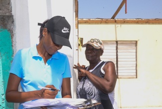 Ministry of Labour and Social Security Records Officer, Stacey-Ann Coleman (left), documents information being provided by resident of Mitchell Town in Clarendon, Novlette Rhoden, on the extent of damage sustained during Hurricane Beryl’s passage. The occasion was a visit to the community by teams from the Ministry on Wednesday (July 10) to assess damage and present relief items to affected residents.

