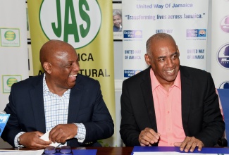 Chairman of the United Way of Jamaica, Dr. Devon Smith (left), sharing pleasantries with Senior Strategist, Ministry of Agriculture, Fisheries and Mining, Michael Pryce, during the launch of the farmers’ rehabilitation fund, at the Private Sector Organisation of Jamaica offices in St. Andrew, on July 12.