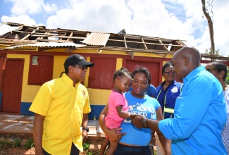Minister of Labour and Social Security, Hon. Pearnel Charles Jr. (right) greets resident of Salmon Town in Manchester, Ann Kay Dixon and daughter (second left), during a tour of the area on July 12. Ann Kay’s house and business were damaged as a result of the passage of hurricane beryl.  Looking on is the Minister of State in the Ministry, Dr. Hon. Norman Dunn.