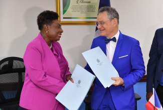 Minister of Culture, Gender, Entertainment and Sports, Hon. Olivia Grange; and Ambassador of the French Republic, His Excellency Olivier Guyonvarch, shake hands following the signing of a Memorandum of Understanding (MOU) on July 24 at the Ministry’s office, 4-6 Trafalgar Road in Kingston. The MOU was signed to strengthen cooperation in Sports between Jamaica and France.