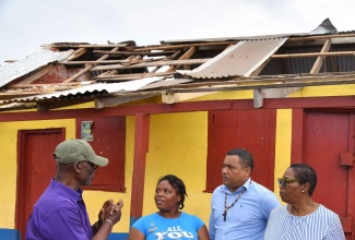 Minister of Local Government and Community Development, Hon. Desmond McKenzie (left), in discussion with Annakay Dixon (second left), during a tour of the Salmond Town community of South Manchester on July 12. Others present (from second right) are Member of Parliament for Manchester Southern, Robern Chin, and Councillor for the Grove Town Division, Iceval Brown.