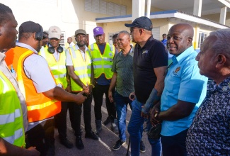 Minister of Health and Wellness, Dr. the Hon. Christopher Tufton (third right), in conversation with a vector-control team working in the community of Rocky Point, Clarendon, on July 25. Others pictured are (from right) Councillor for the Rocky Point Division, Winston Maragh; Member of Parliament for Clarendon South Eastern, Hon. Pearnel Charles Jr. and Deputy Chairman for the Southern Regional Health Authority (SRHA), Michael Stern.
