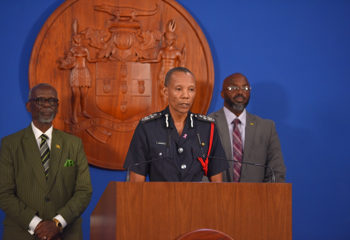 Commissioner, Jamaica Fire Brigade, Stewart Beckford addresses, a press conference at the Office of the Prime Minister. Listening from left are Minister of Local Government and Community Development, Hon. Desmond McKenzie, and Acting Director General, Office of Disaster Preparedness and Emergency Management, Richard Thompson.