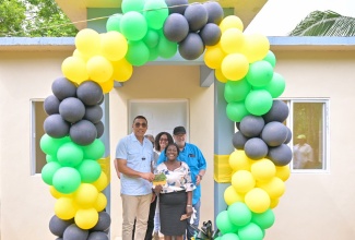 Prime Minister, the Most Hon. Andrew Holness (left), presents New Social Housing Programme (NSHP) beneficiary, Leta Williams, with the keys to her new two-bedroom home in Lodgie Green District in Grantham, Clarendon  on Friday (July 26). Sharing the moment are Member of Parliament for Clarendon North Western, Phillip Henriques, and NSHP officials. 