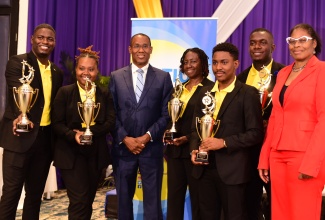 Minister of Finance and the Public Service, Dr. the Hon. Nigel Clarke [third left) and Executive Director, Transformation Implementation Unit (TIU), Maria Thompson Walters (right), share a moment with members of the Ministry of Justice’s winning debate team, during the finals of the 2024 Public Sector Debate Competition held on August 7 at The Jamaica Pegasus hotel in New Kingston. The Ministry defeated the Administrator-General’s Department (AGD). The team members (from left) are Demoy Whitely, Joanalee Robertson, Claudia Powell, Payton Patterson and Oschain Haynes.