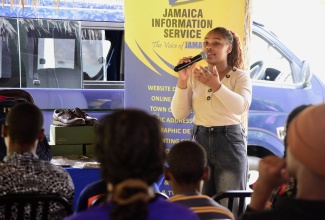 Special Projects Officer, Jamaica Information Service (JIS), Romona Geohaghan, presents career information on various professions to the residents of the Mount Olivet Boys’ Home in Manchester, during the agency’s Annual Back-to-School Treat on Saturday, August 17.