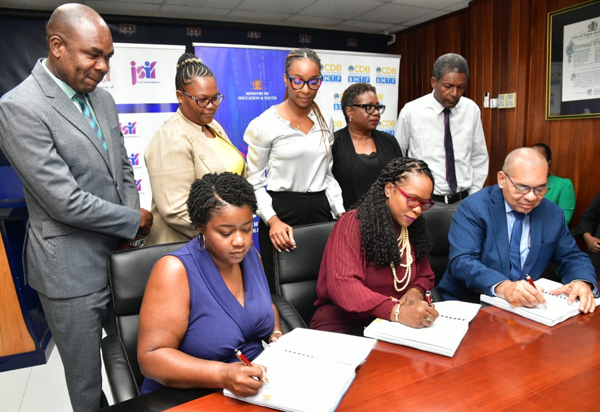Permanent Secretary in the Ministry of Education and Youth, Dr. Kasan Troupe (seated centre); General Manager, Finance, Standards, Procurement, Jamaica Social Investment Fund, Orville Hill (seated right), and Director, Build Rite Construction, Chantay Campbell (seated left), affix their signatures to documents for expansion and rehabilitation works at the Mount Moriah Primary School in St. Ann,  at the Ministry’s Heroes Circle offices in Kingston on August 8. Observing from left are Member of Parliament St. Ann Southwestern, Hon. Zavia Mayne; Principal, Mount Moriah Primary School, Kerrol Lyons and other stakeholders.