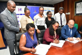 Permanent Secretary in the Ministry of Education and Youth, Dr. Kasan Troupe (seated centre); General Manager, Finance, Standards, Procurement, Jamaica Social Investment Fund, Orville Hill (seated right), and Director, Build Rite Construction, Chantay Campbell (seated left), affix their signatures to documents for expansion and rehabilitation works at the Mount Moriah Primary School in St. Ann,  at the Ministry’s Heroes Circle offices in Kingston on August 8. Observing from left are Member of Parliament St. Ann Southwestern, Hon. Zavia Mayne; Principal, Mount Moriah Primary School, Kerrol Lyons and other stakeholders.


