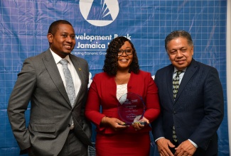 Minister of Agriculture, Fisheries & Mining, Hon. Floyd Green (left) and General Manager of the Development Bank of Jamaica (DBJ) Credit Enhancement Facility (CEF), David Wan, share a photo opportunity with NCB Business Banker, Tolcia Barnes, at the CEF Superstars Awards ceremony held on August 14 at the Courtyard Marriott in Kingston.

