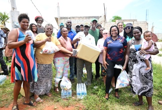 Minister of Local Government and Community Development, Hon. Desmond McKenzie (centre), is surrounded by residents of Flagaman during a tour of sections of St. Elizabeth on Saturday (August 10) to get a first-hand look at hurricane damage and distribute relief items.

