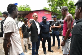 Minister of National Security, Hon. Dr. Horace Chang (second left), addresses residents of the Cherry Tree Lane community in Clarendon, on August 12.