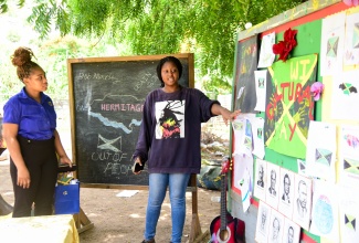 Special Projects Officer, Jamaica Information Service (JIS), Romona Geohaghan (left), is shown several pieces of artwork done by students attached to the Teach the Youth Summer Programme Centre in Hermitage, St. Andrew, by the facility’s Manager, Abygale Brown. The pieces were done for the youngsters’ ‘Culture Corner’, during their ‘Culture Day’ activity at the Centre on Tuesday (July 30). The programme, which commenced in 1999, is an annual initiative geared towards extending assistance, through academics and other interventions, to students residing in Papine and adjacent communities in St. Andrew. This year’s programme was facilitated by organisers from the University of Technology, Jamaica (UTechJa) Students’ Union Council in tandem with the JIS, under the theme ‘Empower to Inspire: Nurturing Tomorrow’s Leaders’.