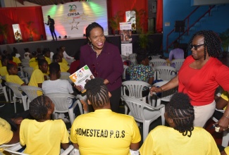 Permanent Secretary in the Ministry of Education and Youth, Dr. Kasan Troupe (left), converses with wards of the State from the Homestead Place of Safety, during the Child Protection and Family Services Agency (CPFSA) talent competition showcasing culinary, visual and performing arts, held at the Chinese Benevolent Association in Kingston, on Thursday (August 29). Sharing the moment is the CPFSA team leader from Manchester, Donna Fuller (right). 