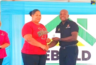 Minister of Labour and Social Security, Hon. Pearnel Charles Jr., presents a grant cheque to St. Elizabeth resident, Maricka Aiken, during the Rebuild Jamaica Initiative handover ceremony, held at the Ministry’s office in Santa Cruz, on Thursday  (August 29).
