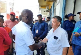 Executive Director, National Solid Waste Management Authority (NSWMA), Audley Gordon (left), greets Chief Operating Officer, Bashco Trading, Juan Machado, during a recent walk-through of the downtown Kingston business district. The NSWMA was among the government entities participating in a multi-agency operation in the area, aimed at ensuring businesses adhere to the country’s laws. The operation, conducted between August 14 and 16, was led by the Kingston and St. Andrew Municipal Corporation (KSAMC).

