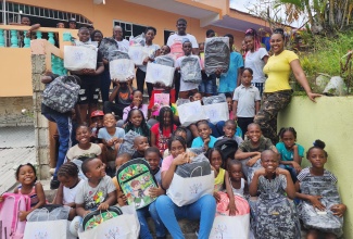 Founder and Head of the Tameka Hill Foundation, Tameka Hill (right), with children at a back-to-school treat, held recently at the Pentecostal City Mission Church Inc, in Mount Ogle, St. Andrew.

