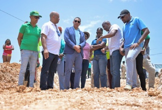 Prime Minister, the Most Hon. Andrew Holness (third left), and Minister without Portfolio in the Ministry of Economic Growth and Job Creation, Hon. Robert Morgan (right), observe repair works being done on a section of the Pamphret main road in St. Thomas, on August 14. Also pictured are (from left) Mayor of Morant Bay, Councillor Louis Chin; Member of Parliament for St. Thomas Western, James Robertson; Television Jamaica journalist, Jamaila Maitland; and Senior Director at the National Works Agency, Varden Downer.

