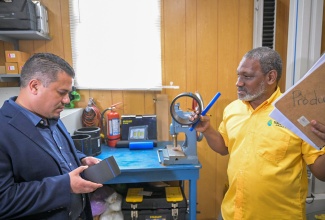Minister without Portfolio in the Ministry of Economic Growth and Job Creation with Responsibility for Water, Senator the Hon. Matthew Samuda (left), is shown some of the products manufactured by Isratech Jamaica Limited (IJL) by the company’s Quality Manager, Harold Graham. The Minister toured IJL’s Shooter’s Hill headquarters in Manchester on August 23.

