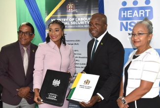 Minister of Labour and Social Security, Hon. Pearnel Charles Jr (second right) and Managing Director of the HEART/NSTA Trust, Dr. Taneisha Ingleton (second left), display copies of the Memorandum of Understanding (MOU) between the entities, which is aimed at enhancing the Overseas Employment Programme. The signing took place at the Ministry’s North Street offices in Kingston on Friday (July 26). Sharing the moment are State Minister, Dr. the Hon. Norman Dunn and Permanent Secretary in the Ministry, Colette Roberts Risden. The agreement aims to foster a robust and dynamic labour market by equipping workers with employment readiness training and other skillsets required to succeed in the local and global workspace.

