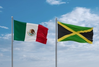 Jamaica and Mexico flags waving together in the wind. 