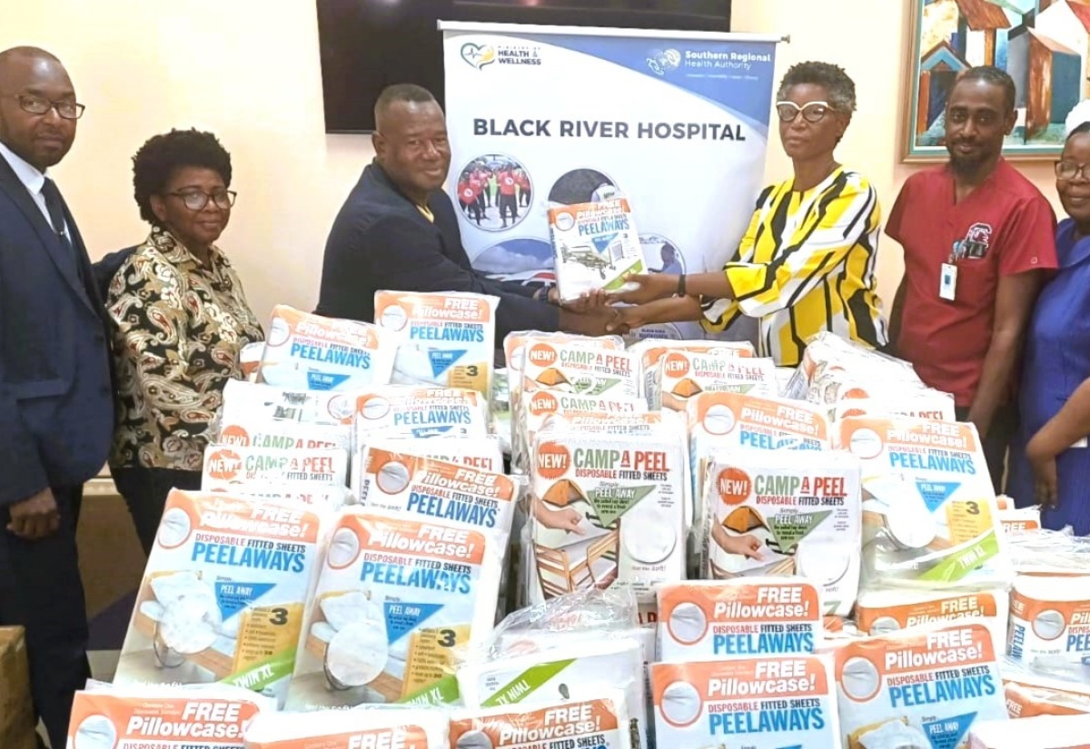 Chief Executive Officer of the Black River Hospital, in St. Elizabeth, Diana Brown Miller (third right), accepts a donation of disposable bed sheets from President of the Parottee Enrichment Project Inc., Albert Daley (third left), during a handover ceremony held at the hospital on Tuesday (August 13). 
Also pictured are (from left)  Board members of the organisation,  Pastor Otis Lewis and Donna Drummond; Senior Medical Officer at the Black River Hospital, Dr. Sheriff Imoru and Director of Nursing Services at the facility, Maria Stamp.